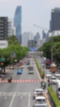 Bokeh view of road traffic near MBK Center, Bangkok, Thailand. Blurred background vertical footage.