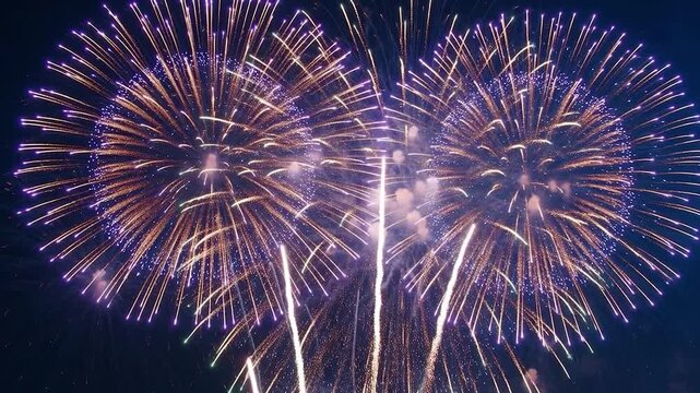 Spectacular fireworks exploding with colorful lights and sparks in the dark night sky during a festival celebration or holiday