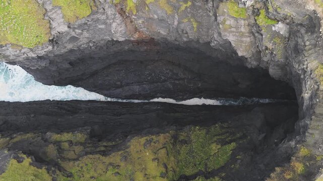 Top down drone view of waves in a cliff inlet at Hag's Head, County Clare, Ireland