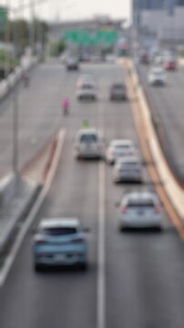 Bokeh view of road traffic in Thonburi district, Bangkok, Thailand. Blurred background vertical footage.