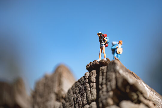 Backpackers reaching mountain top under blue sky