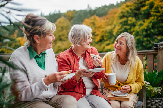 Happy senior women enjoying cup of herbal tea together.
