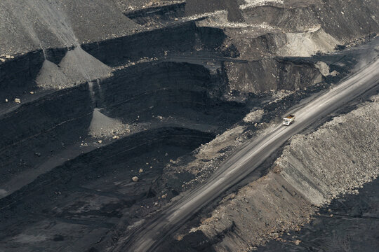 Deep excavation levels exposing dark coal seams in an open-pit coal mine near.