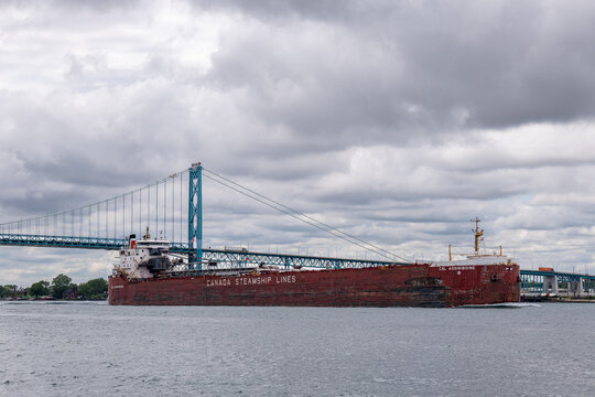 Canada Steamship Lines freighter transits Detroit River near Ambassador Bridge, illustrating cross-border shipping and international trade tariff disputes, July 2026.