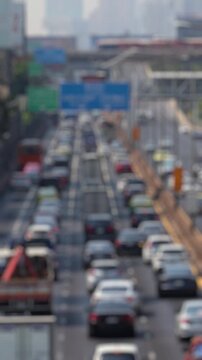 Bokeh view of road traffic in Lumphini district, Bangkok, Thailand. Blurred background vertical footage.