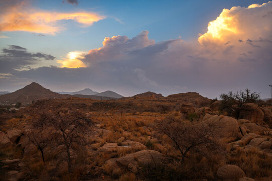 Saudi Arabia Tourism - Scenic sunset sky with golden clouds and storm clouds over Al Taif mountain landscape and desert resort lights, ideal for Saudi National Day and travel campaigns