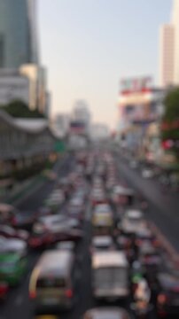 Bokeh view of road traffic near Central World shopping mall, Bangkok, Thailand. Blurred background vertical footage.
