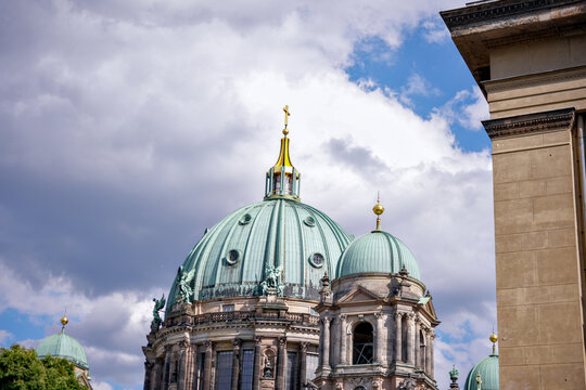 Berlin Cathedral dome and ornate historic architecture beneath dramatic clouds
