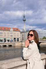 Smiling woman in sunglasses by the Spree with Berlin TV Tower © Moiseii Production