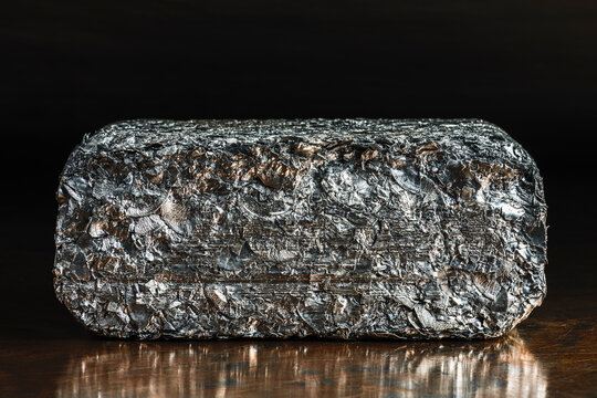 Compressed block of aluminum scrap formed from processed non ferrous metal waste, irregular structure of compacted aluminum fragments. Secondary raw material for metallurgical and metal processing ind