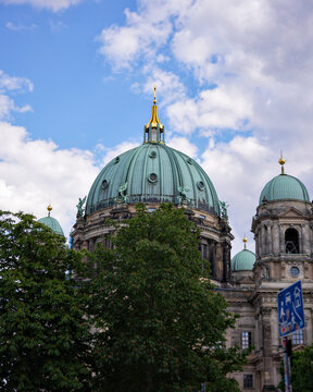 Berlin Cathedral domes and ornate facade beneath a cloudy sky
