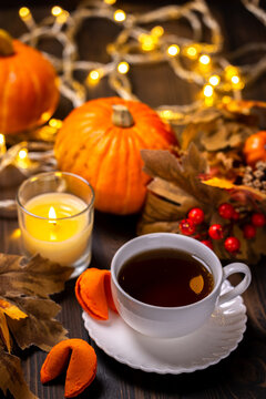 Warm tea, lit candle, and fortune cookies creating cozy autumn atmosphere