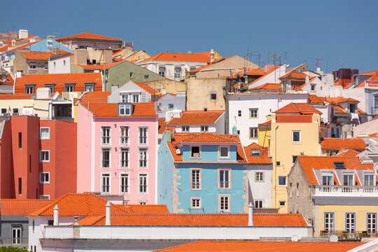 Dense urban view of Lisbon with colorful residential buildings and traditional red tiled rooftops, Portugal.
