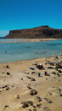 Vertical video low aerial glide over shallow water at Balos