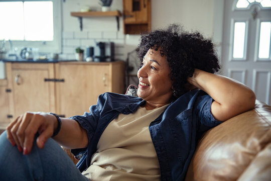Smiling woman relaxing on sofa at home