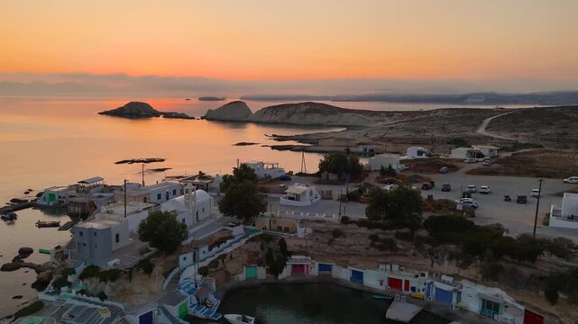 Early morning sunlight during a beautiful sunrise over the Aegean sea seen from the shore of Mandrakia on the Greek island Milos in Greece. Unique landscape on the coastline, natural blue ocean water