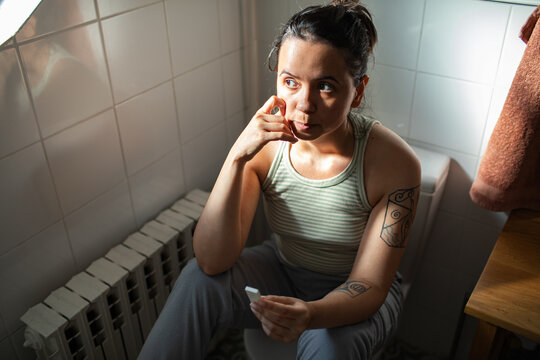 Worried young woman reading pregnancy test in bathroom