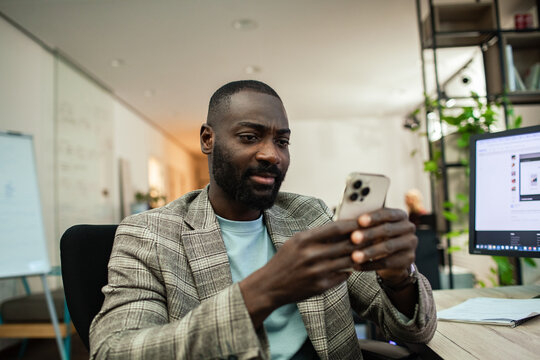 Business professional checking smartphone in modern office