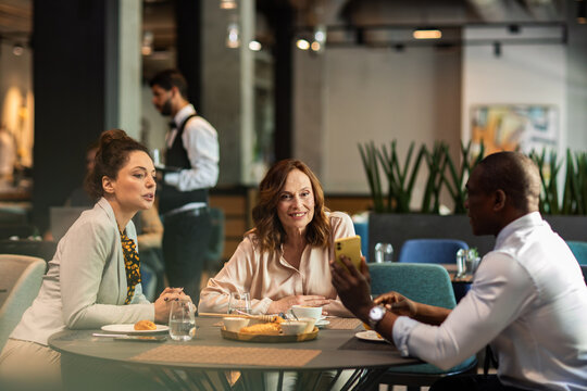 Business colleagues meeting over coffee in modern cafe