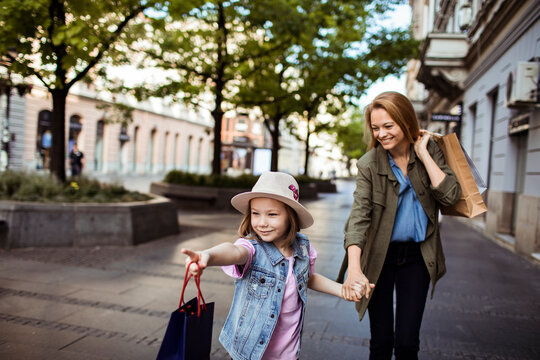Mother and daughter shopping together on city street