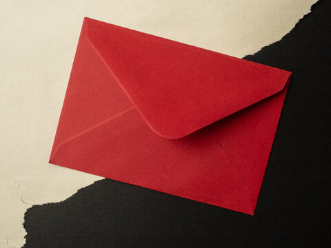 Red Envelope On Contrasting Black And Cream Paper Background For Invitation Or Valentine Mail