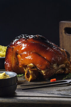 Eisbein also known as pork knuckle presented on wooden board