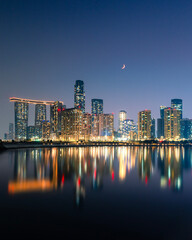 Abu Dhabi Skyline at Night with Crescent Moon and Waterfront Reflections © Giuseppe