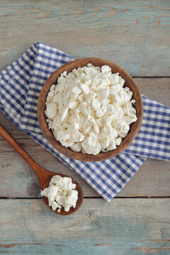 Cottage cheese in a wooden bowl with a wooden spoon