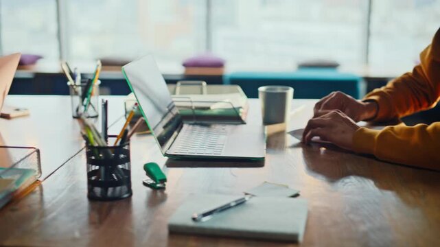 Closeup man hands folding paper office desk. Camera pan woman typing laptop.