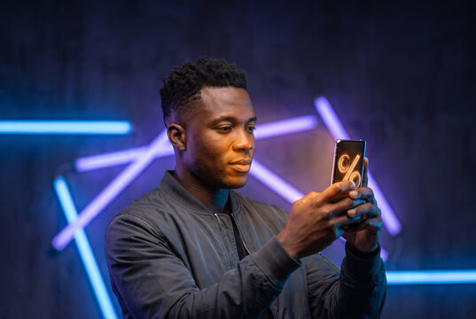 Man checking a glowing discount notification on smartphone at night