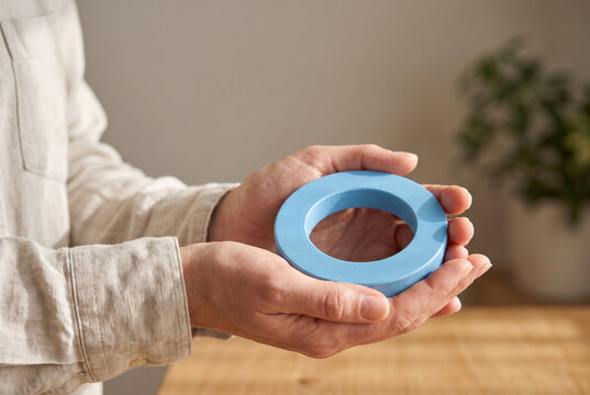 Hands gently holding wooden blue circle for diabetes awareness