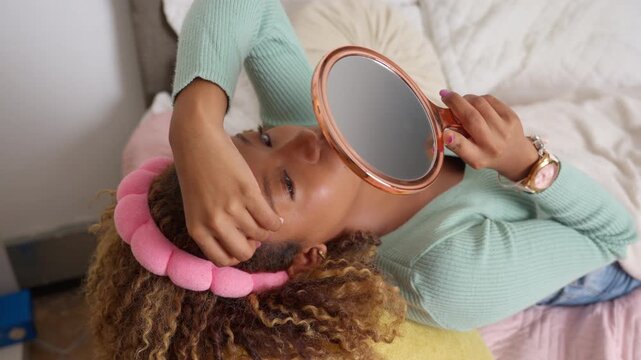 Young black woman performing facial massage with gua sha