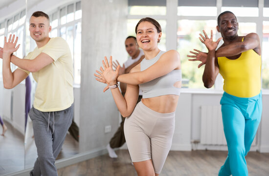 During dance workshop, European girl with team of like-minded multinational people learn to perform elements of energy electro dance. Studio school for amateur and professional dancers
