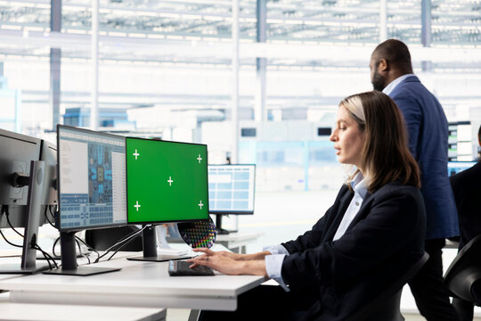 Woman models integrated circuits on green screen PC in R&D office