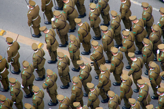 Aerial view of a squad of Chilean police officers (Carabineros) marching.