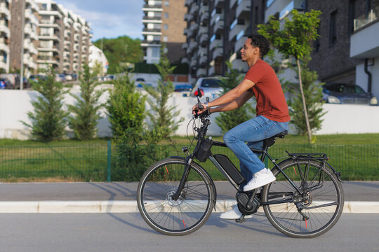 Sustainable urban mobility, young man riding an electric bike in the city