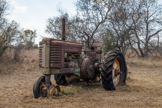 An old rusty tractor sitting in a field