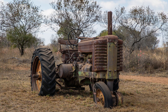 An old rusty tractor sitting in a field