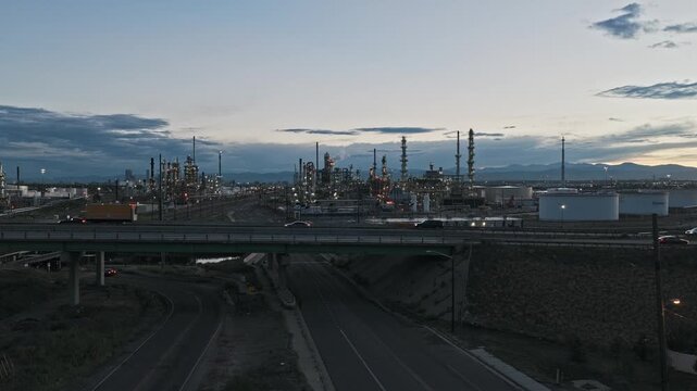 Wide view of industrial zone oil refinery reveal shot with highway and cars drone video Denver Colorado 4K