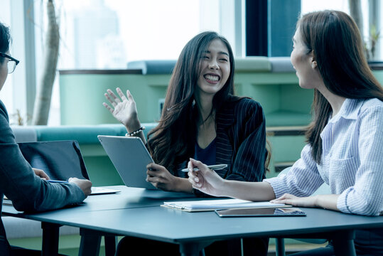 Gen Z Asian Business Consultants Collaborating and Sharing Ideas in a Modern Office and Coworking Space