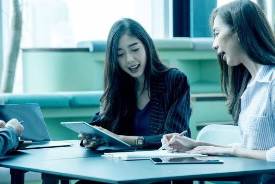 Gen Z Asian Business Consultants Collaborating and Sharing Ideas in a Modern Office and Coworking Space