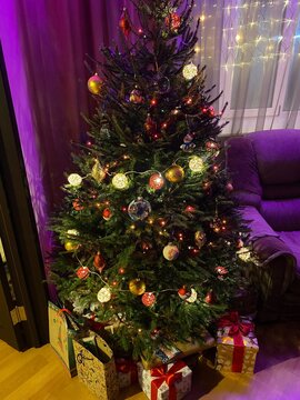 Decorated Christmas tree with string lights standing in a living room