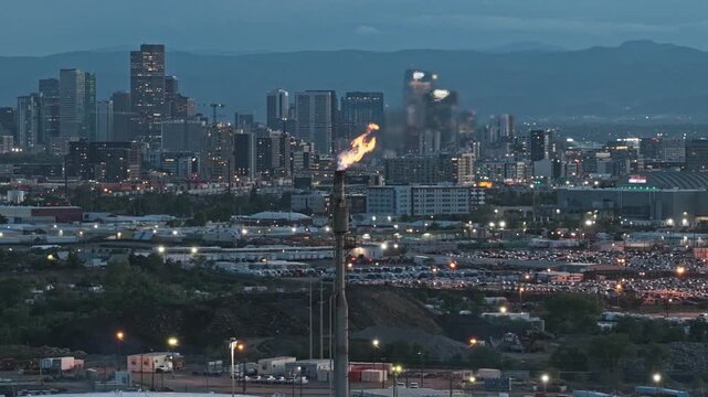 Industrial chimney with flame coming out oil refinery view with city skyline america drone video close up shot Denver Colorado 4K