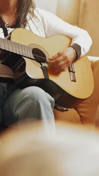 Long-haired musician skillfully playing an acoustic guitar