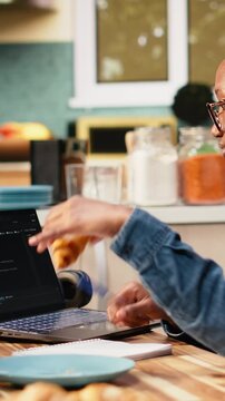 Vertical frame: Adult woman uses laptop to write programming code and develop software. Programmer focuses on debugging scripts, analyzing data and working with a terminal window during coding work.