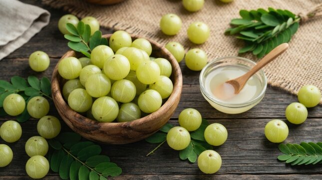 Fresh amla gooseberries in a wooden bowl with juice