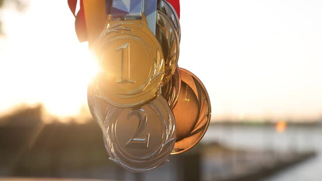 Gold, silver and bronze medals outdoors, closeup. Slow motion effect