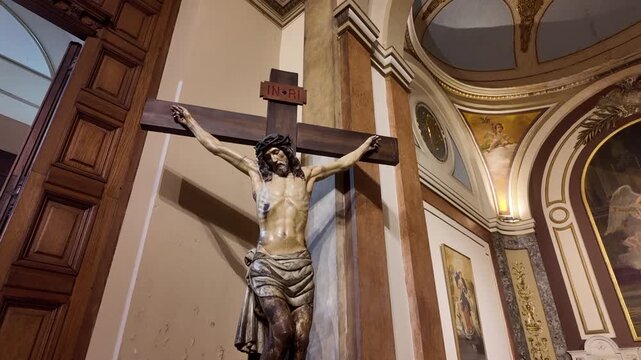 Tilt-down shot showing the historic Christ on the Cross sculpture inside the Metropolitan Cathedral of Buenos Aires.