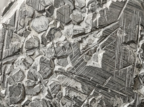 Macro close-up of zinc metal crystal structure. Industrial metallic texture with geometric patterns and sharp edges