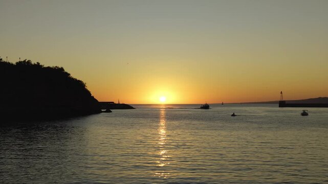 Scenic view of the sun setting over the Mediterranean Sea with boat silhouettes in Marseille